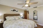 Master bedroom with comfortable king bed, ceiling fan, beach decor